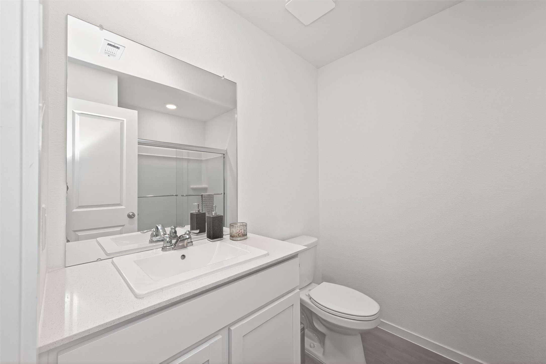 10720 Ellerston Road Cleveland, TX 77327 - Photo 19 of 32 This bathroom features a modern design with a clean white vanity, a large mirror, and a glass-enclosed shower. The space is bright and streamlined, offering a fresh and inviting atmosphere.