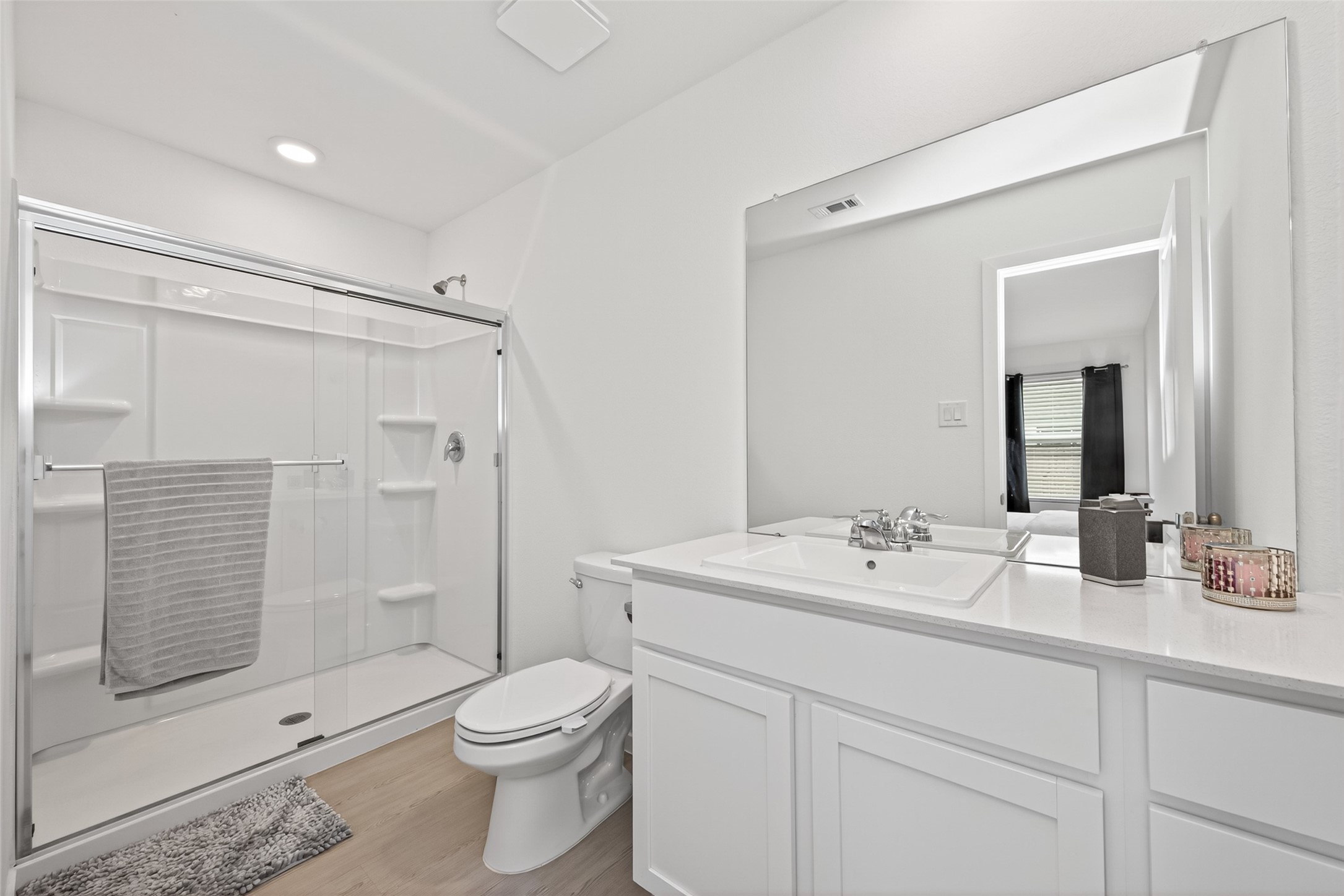 10720 Ellerston Road Cleveland, TX 77327 - Photo 25 of 32 This bathroom features a modern, clean design with a spacious glass-enclosed shower, a large mirror above a white vanity, and sleek fixtures. The neutral color palette creates a bright and inviting space.