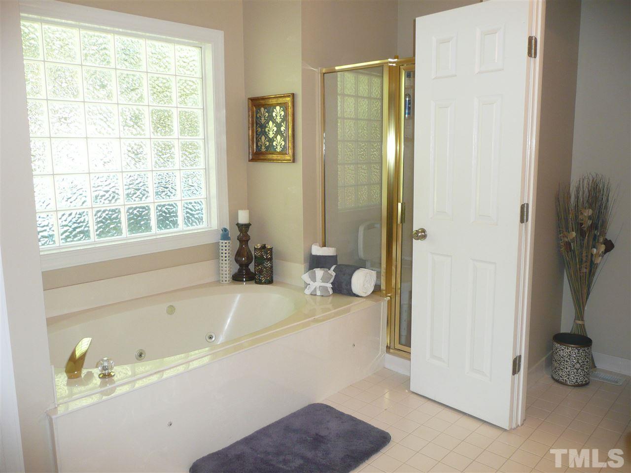 2604 Sunnystone Way Raleigh, NC 27613 - Photo 12 of 25 a bathroom with a tub a sink and a shower