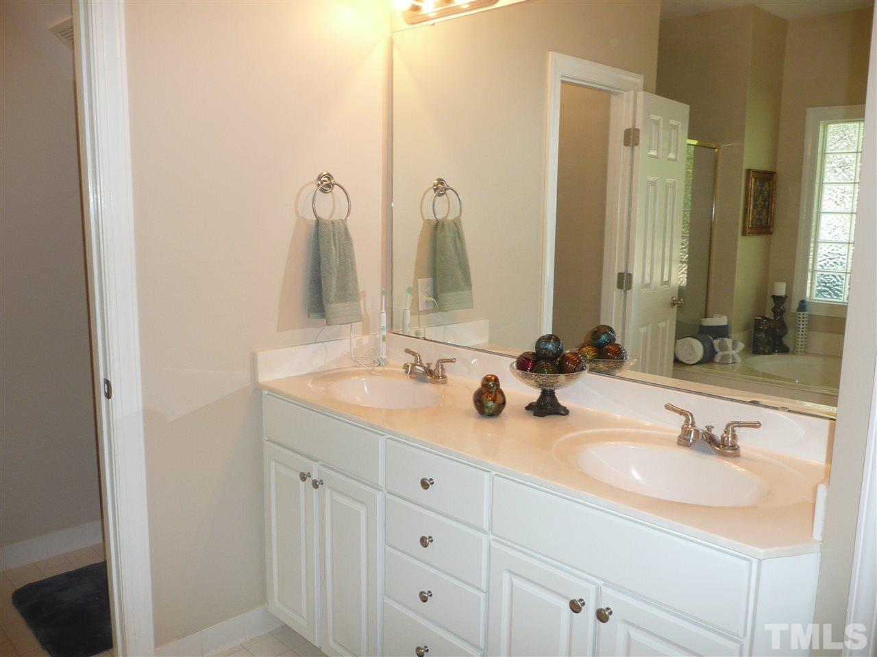 2604 Sunnystone Way Raleigh, NC 27613 - Photo 13 of 25 a bathroom with double vanity sinks and a mirror