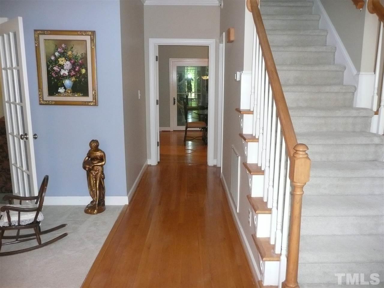 2604 Sunnystone Way Raleigh, NC 27613 - Photo 3 of 25 a view of a hallway with wooden floor and stairs