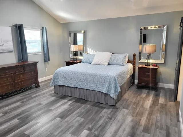 a bedroom with a bed window and mirror