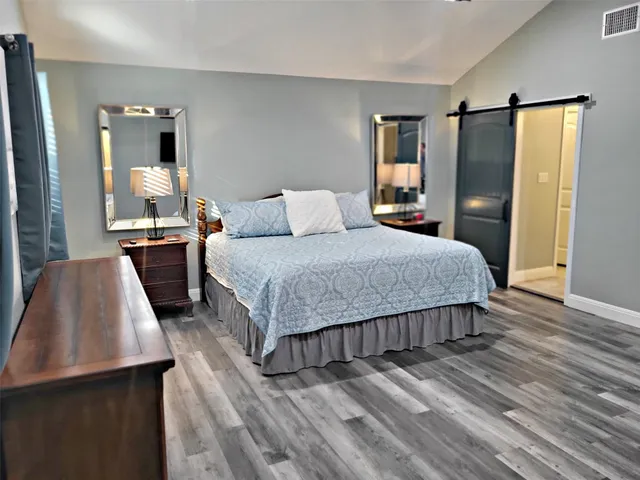a view of a livingroom with wooden floor and a flat screen tv