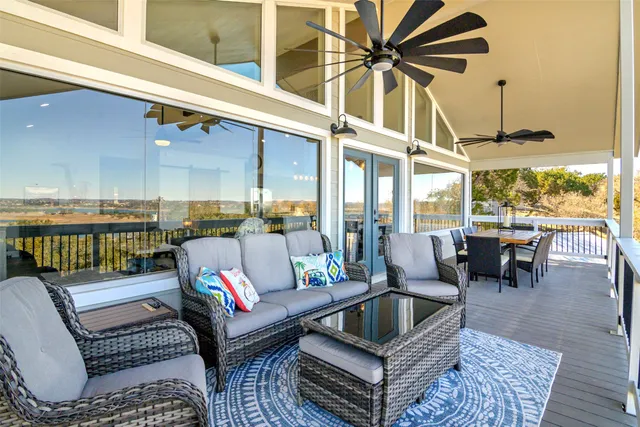 a living room with furniture a floor to ceiling window and flat screen tv
