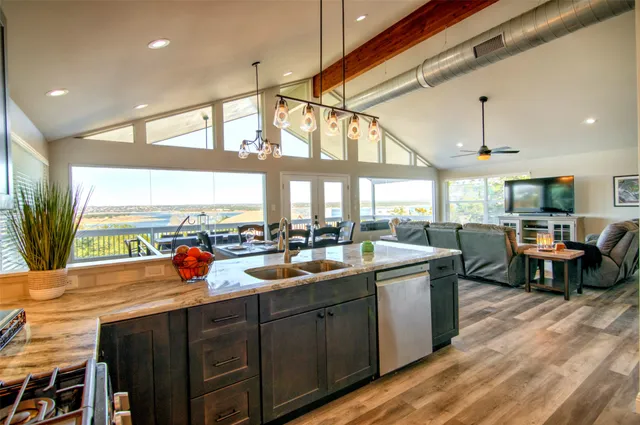 a kitchen with stainless steel appliances granite countertop a sink refrigerator stove and microwave