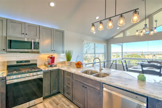 a view of a dining room and livingroom with furniture wooden floor a chandelier