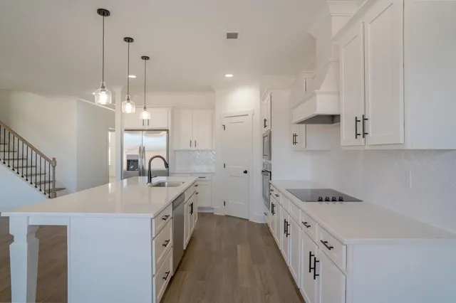 a kitchen with kitchen island a stove a sink and a refrigerator