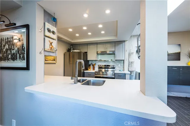 a kitchen with stainless steel appliances a refrigerator sink and stove