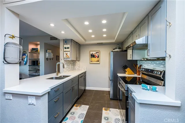 a kitchen with a sink a stove and chairs