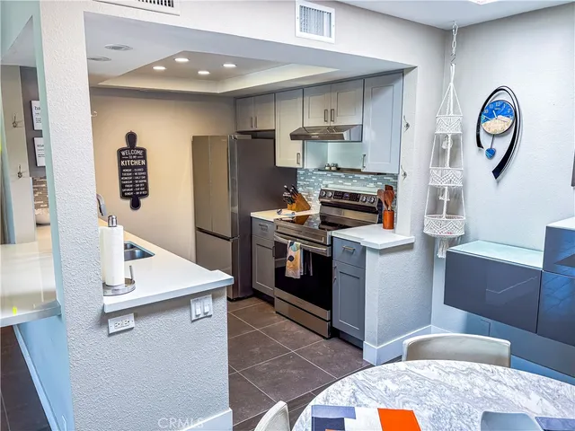 a kitchen with stainless steel appliances granite countertop a stove a sink and a refrigerator