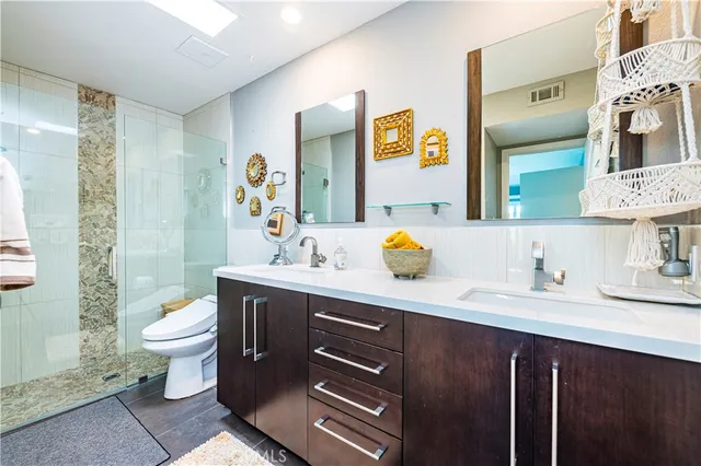 a bathroom with a granite countertop toilet sink and mirror