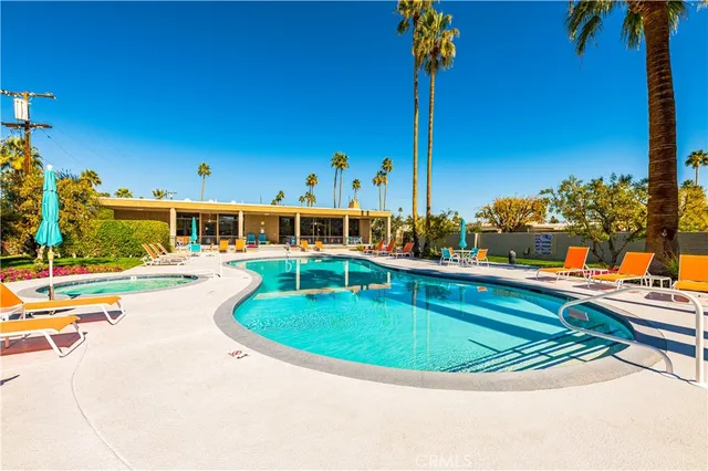 a view of a swimming pool with a lawn chairs under an umbrella