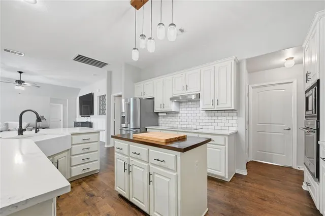 a kitchen with appliances a sink a counter top space and cabinets