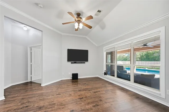 a view of a livingroom with wooden floor and a ceiling fan