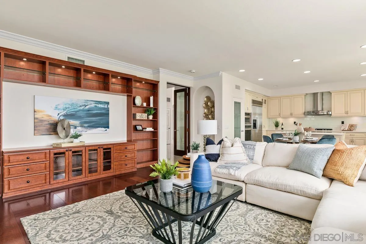 7337 Melodia Terrace Carlsbad, CA 92011 - Photo 11 of 42 a living room with furniture a wooden floor and kitchen view