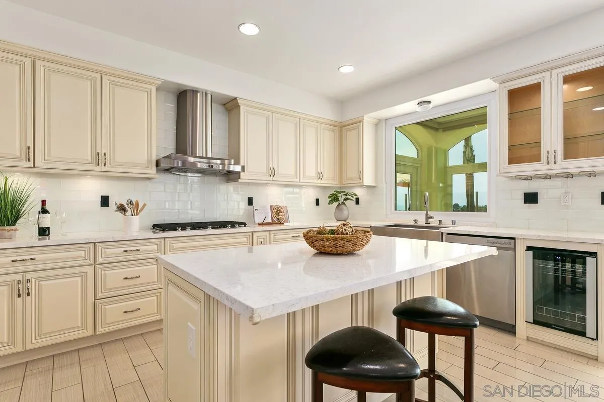 7337 Melodia Terrace Carlsbad, CA 92011 - Photo 13 of 42 a kitchen with a sink a stove and white cabinets