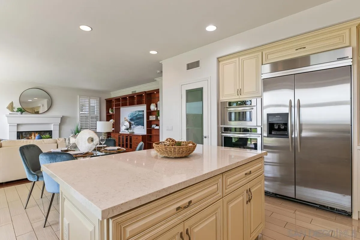 7337 Melodia Terrace Carlsbad, CA 92011 - Photo 16 of 42 a kitchen with a refrigerator and a view of living room
