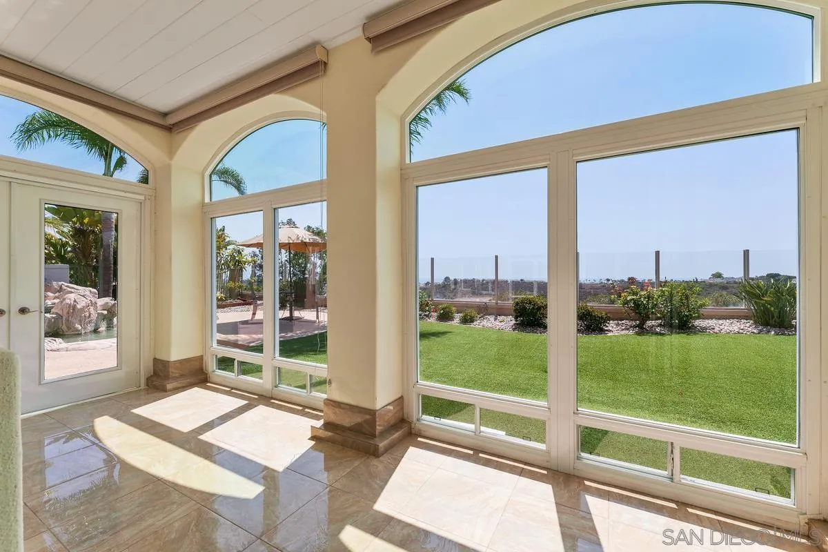 7337 Melodia Terrace Carlsbad, CA 92011 - Photo 17 of 42 a living room with a floor to ceiling windows and a table