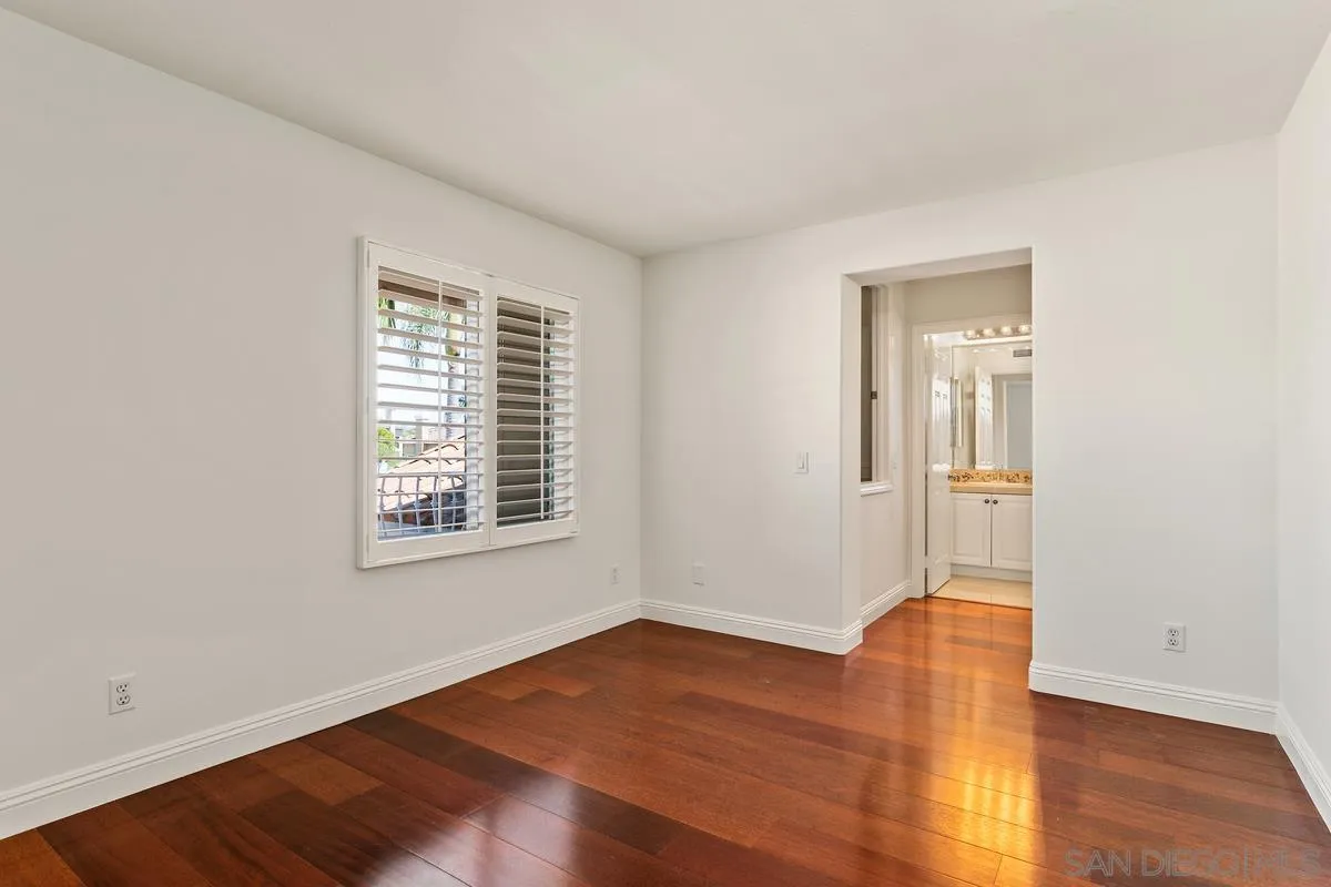 7337 Melodia Terrace Carlsbad, CA 92011 - Photo 32 of 42 a view of an empty room with wooden floor and a window