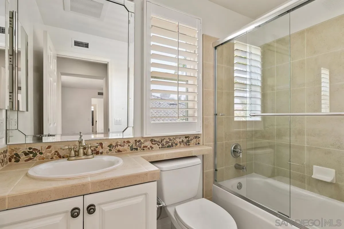 7337 Melodia Terrace Carlsbad, CA 92011 - Photo 33 of 42 a bathroom with a granite countertop sink toilet and shower