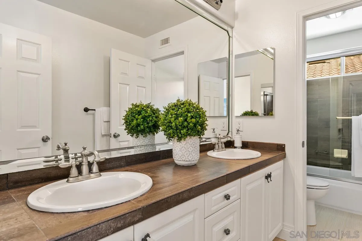 7337 Melodia Terrace Carlsbad, CA 92011 - Photo 35 of 42 a bathroom with a double vanity sink and a mirror