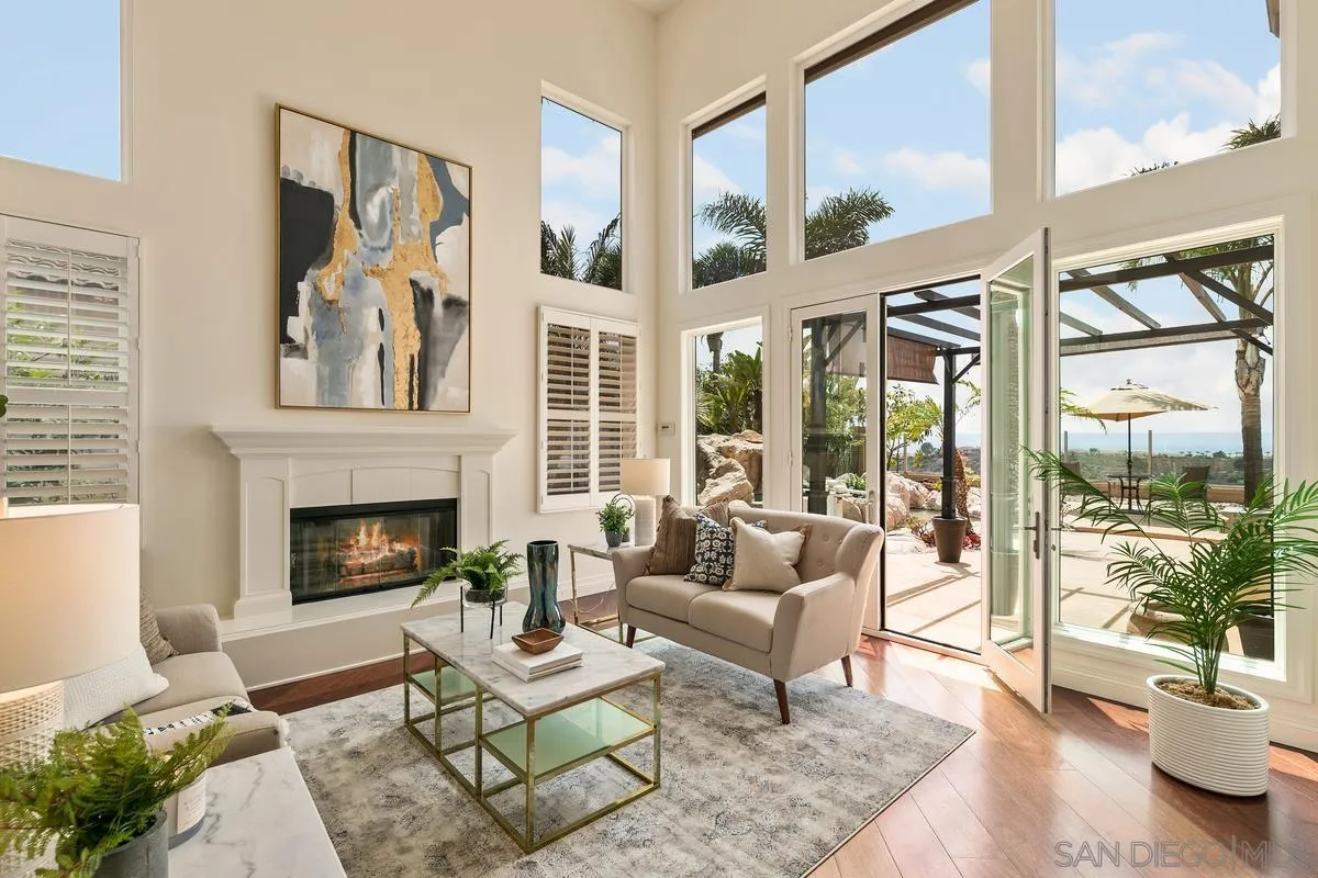 7337 Melodia Terrace Carlsbad, CA 92011 - Photo 4 of 42 a living room with furniture large windows and a fireplace