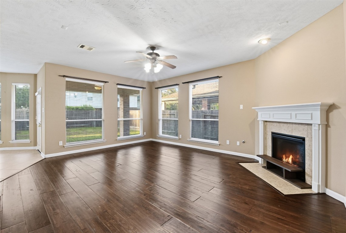 24938 Crystal Stone Lane Katy, TX 77494 - Photo 13 of 50 a view of an empty room with wooden floor fireplace and a window