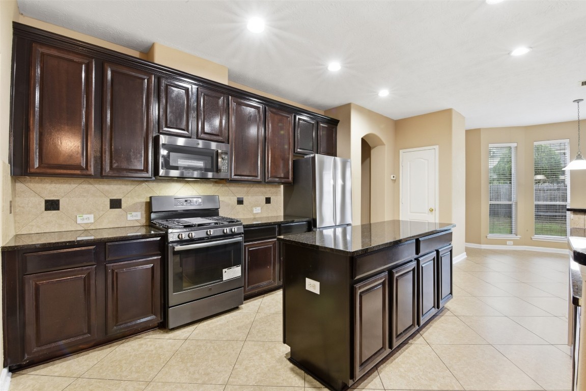 24938 Crystal Stone Lane Katy, TX 77494 - Photo 22 of 50 a kitchen with stainless steel appliances granite countertop a stove a sink dishwasher and a refrigerator
