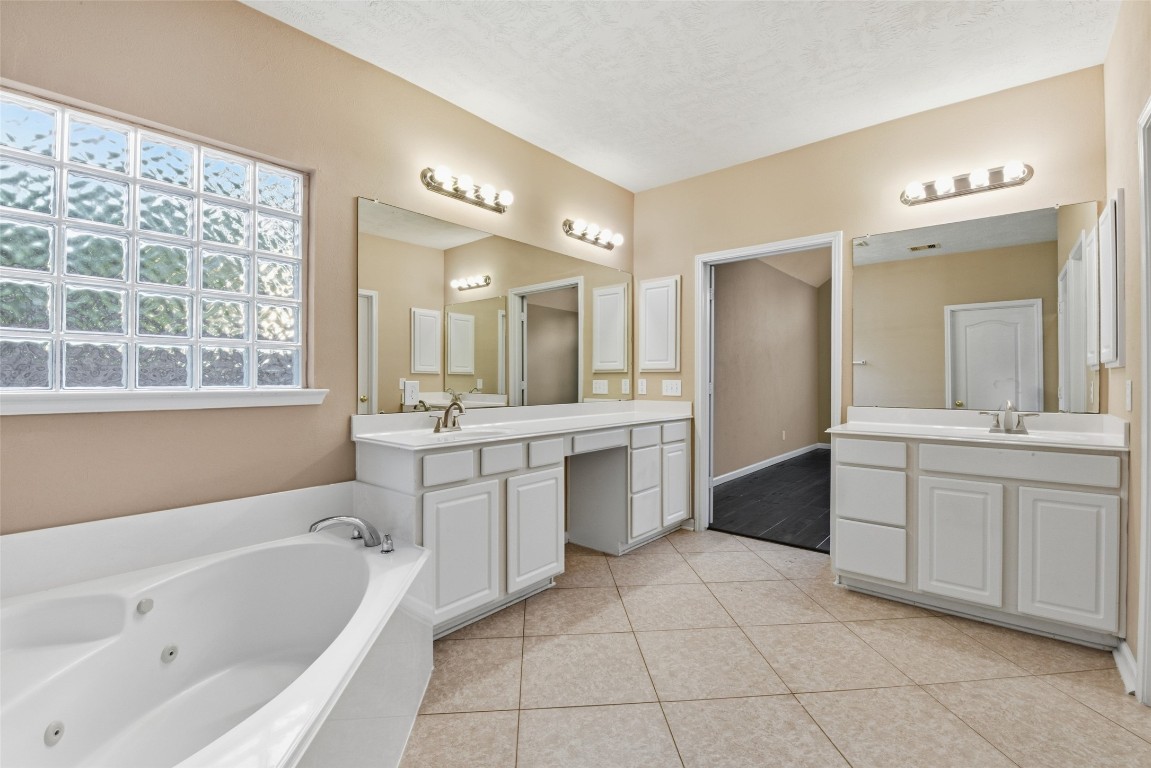 24938 Crystal Stone Lane Katy, TX 77494 - Photo 31 of 50 a large bathroom with a large tub sink vanity and granite
