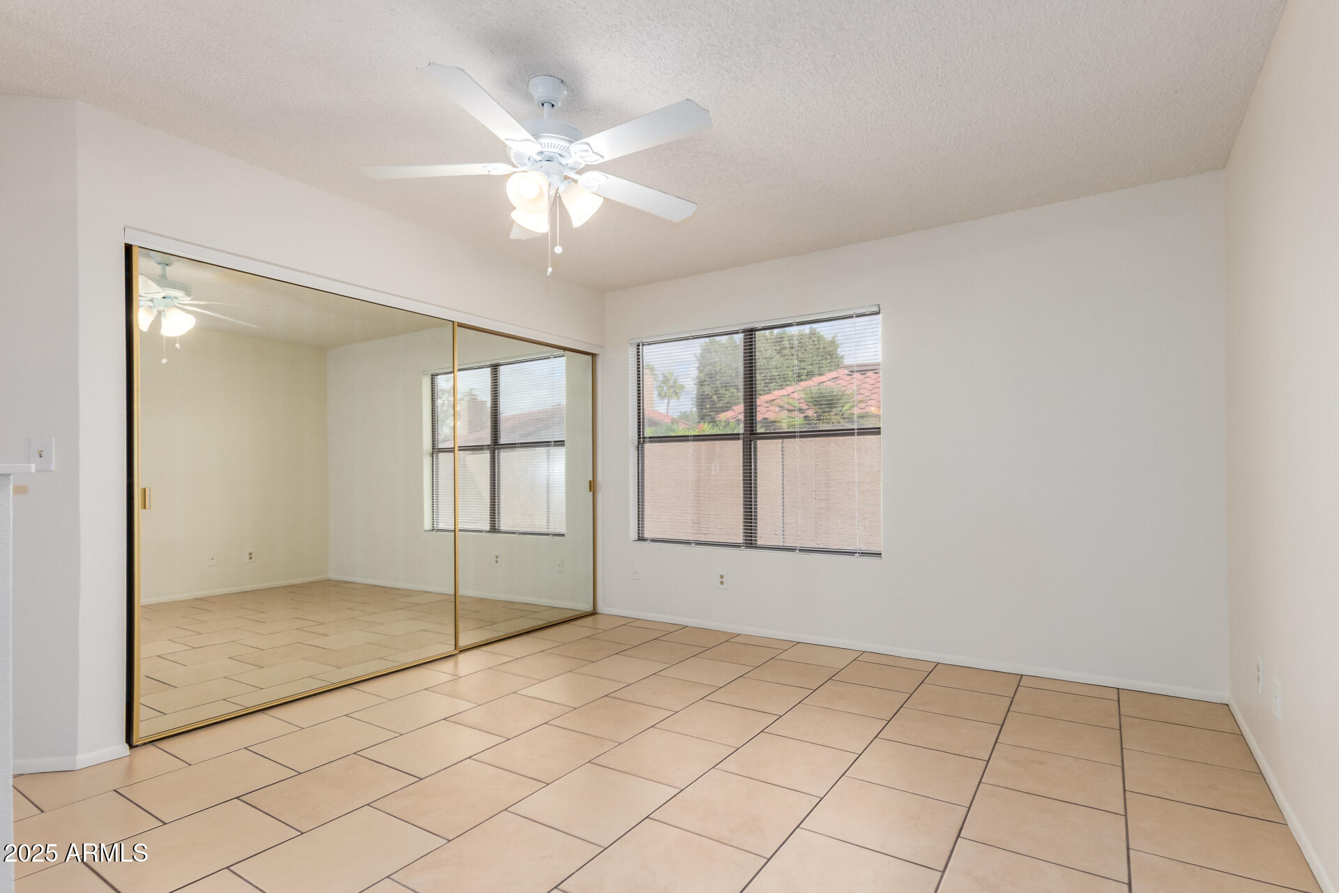 4346 East Sandia Street, Unit 5815 Phoenix, AZ 85044 - Photo 10 of 20 an empty room with chandelier fan and windows