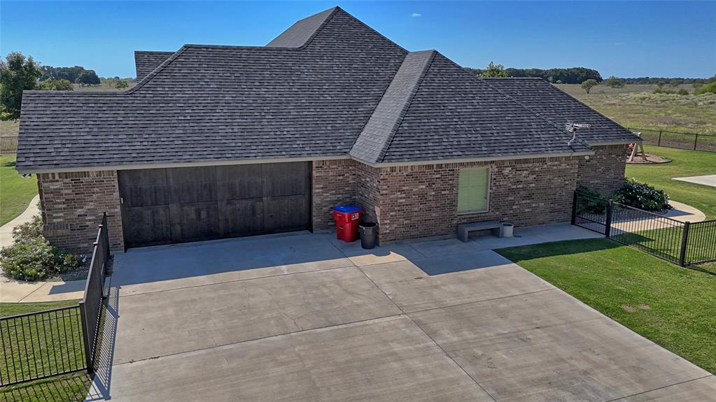 1150 Lone Star Road Bowie, TX 76230 - Photo 7 of 38 a front view of a house with a yard and garage