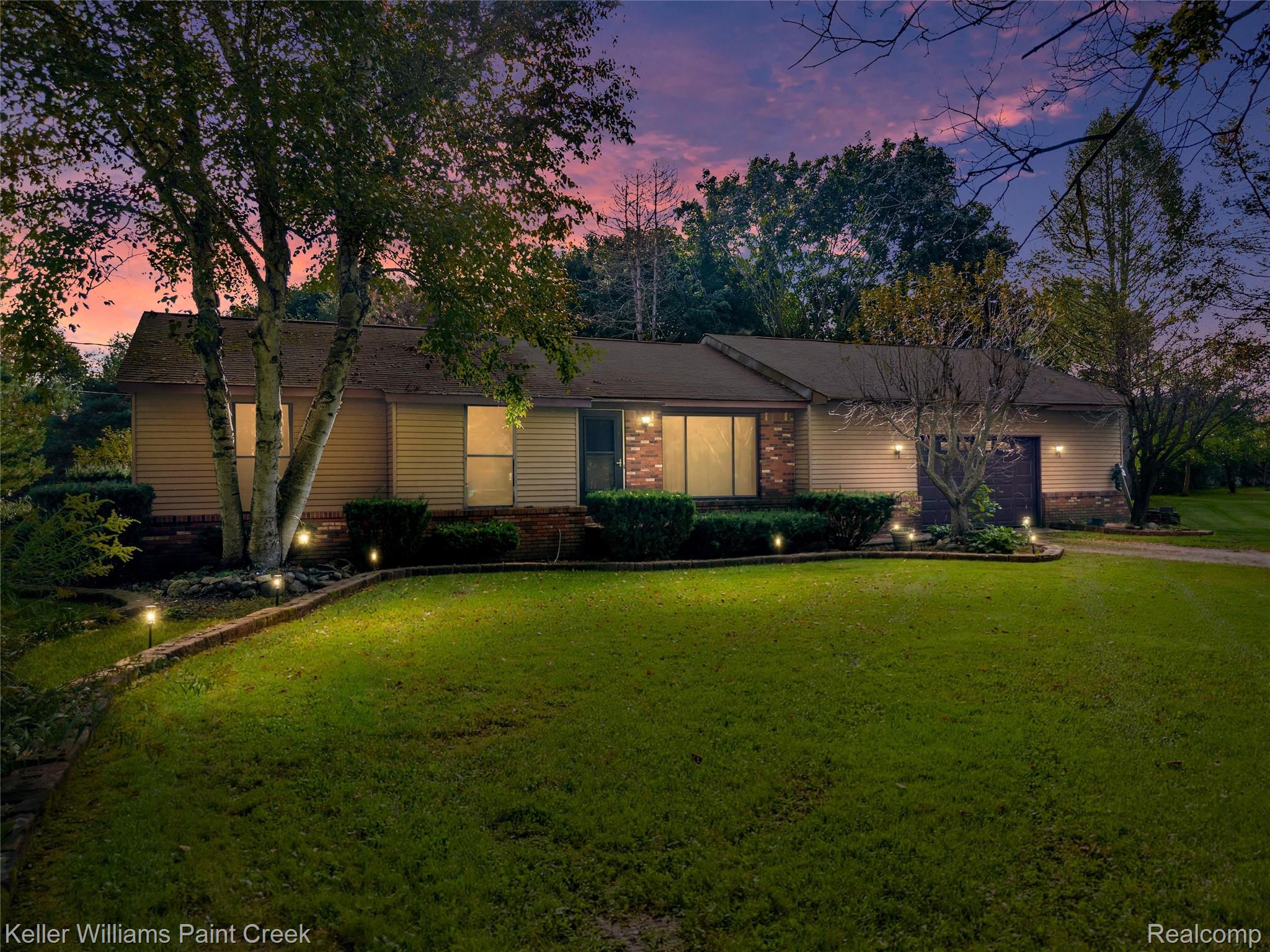 5077 Pinckney Road Howell, MI 48843 - Photo 1 of 39 Exterior featuring brick and siding, a front lawn with established landscaping, and integrated outdoor lighting