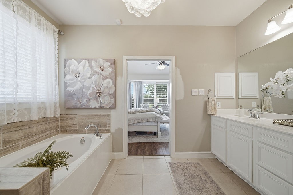 9614 Carson Lane Iowa Colony, TX 77583 - Photo 25 of 50 Elegant spa-like bathroom featuring a double-sink vanity, glass-enclosed shower, relaxing soaking tub with self-cleaning jets, and a stunning bubble chandelier that adds the perfect touch of luxury.