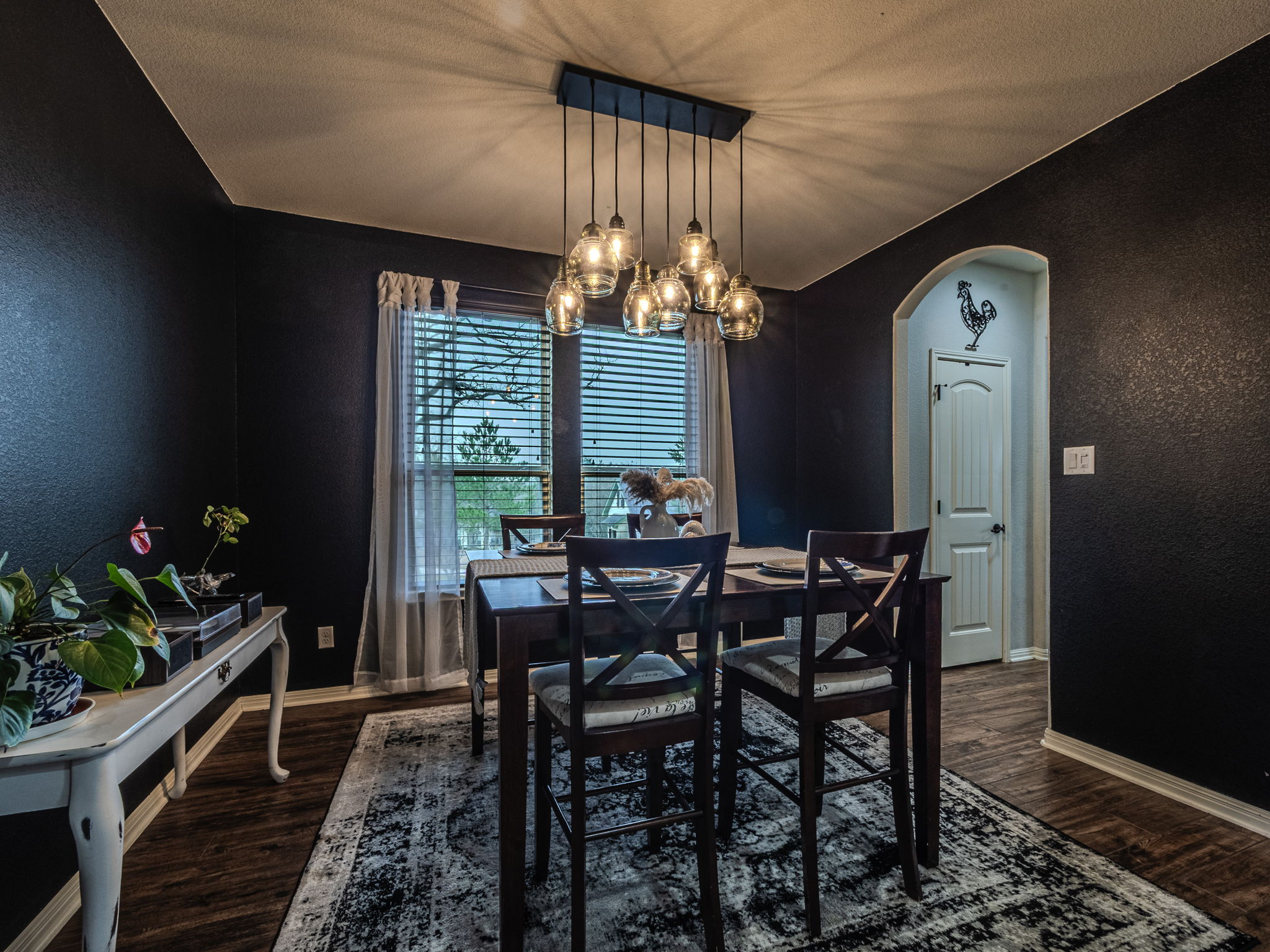 117 Arbor Point Drive Elgin, TX 78621 - Photo 10 of 40 Dining room with arched walkways, a textured wall, a chandelier, and dark wood-style flooring