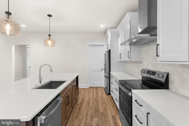 a kitchen with kitchen island a stove a sink and a refrigerator