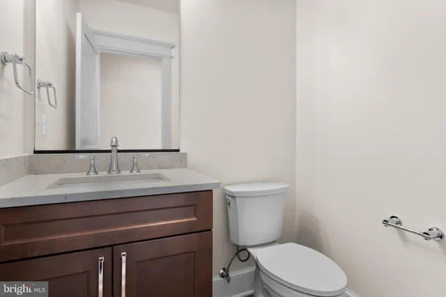 a bathroom with a granite countertop toilet sink and mirror