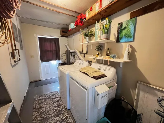 a view of washer and dryer with bathroom in the background