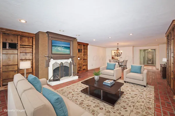 a living room with furniture large window and a fireplace