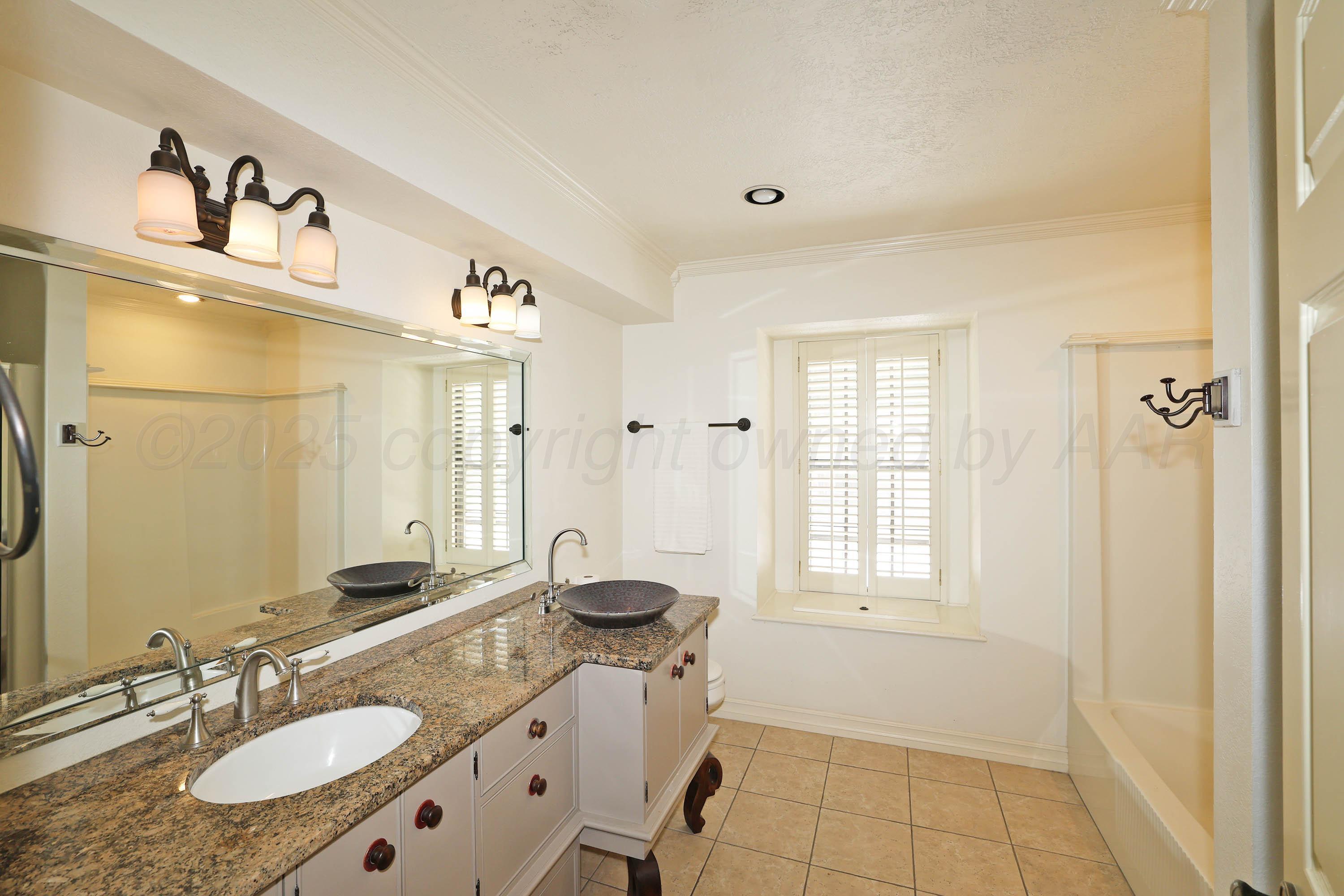 1615 South Bryan Street, Unit 19 Amarillo, TX 79102 - Photo 36 of 53 a bathroom with a granite countertop sink and a mirror