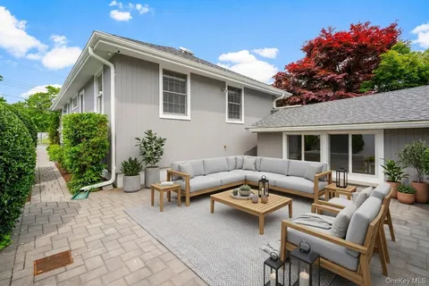 a patio with couches and a potted plant