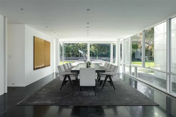 a dining room with wooden floor and a floor to ceiling window