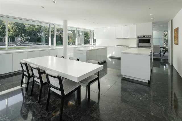 a kitchen with a table chairs sink and cabinets