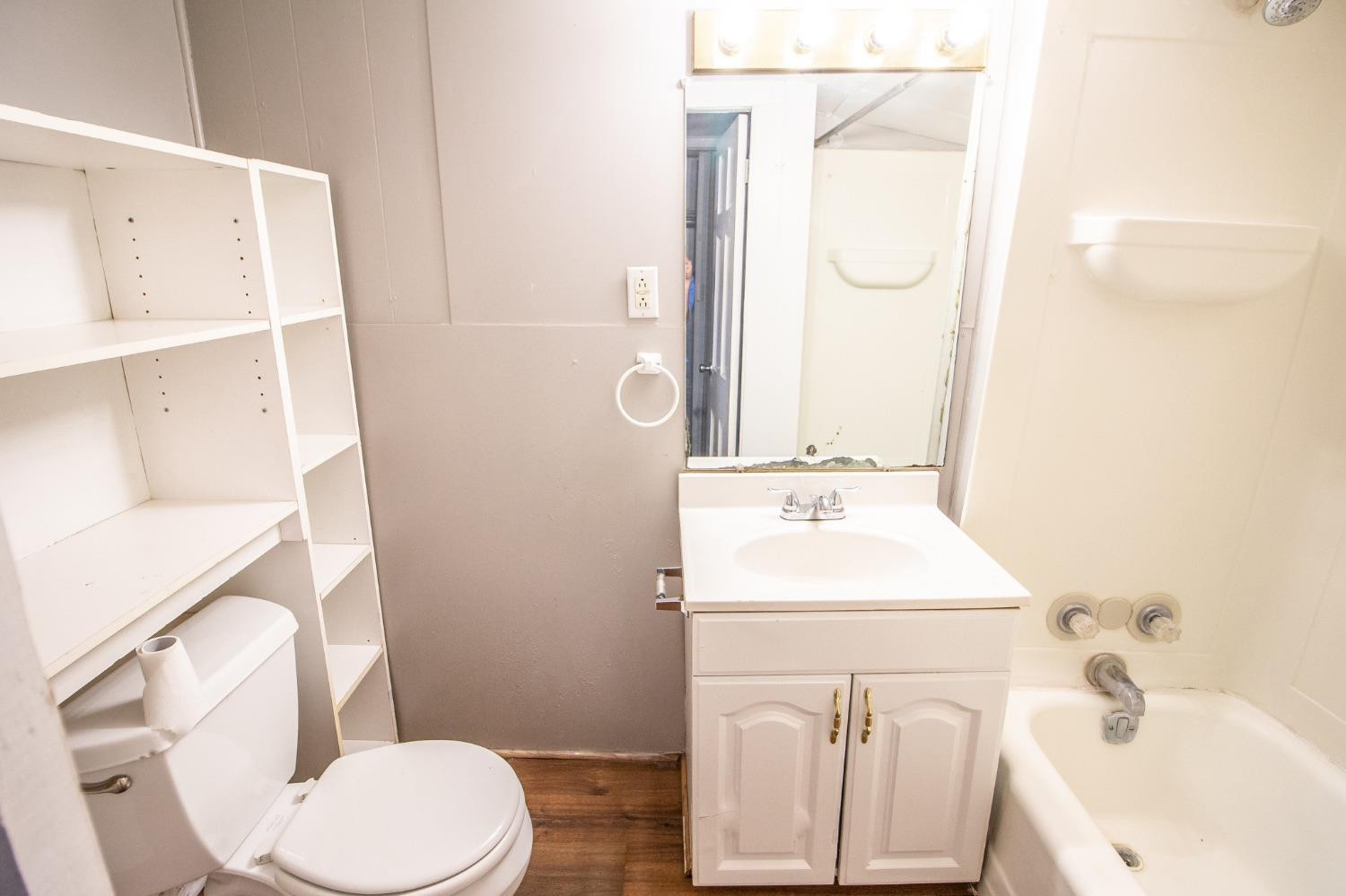2429 27th Street Lubbock, TX 79411 - Photo 12 of 16 a bathroom with a sink a toilet and a mirror
