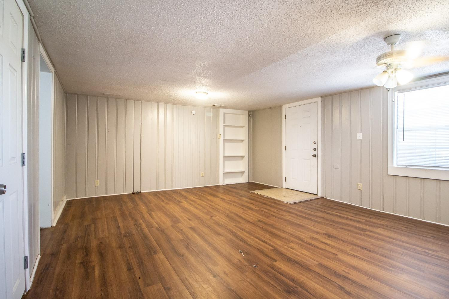 2429 27th Street Lubbock, TX 79411 - Photo 4 of 16 a view of empty room with wooden floor and fan