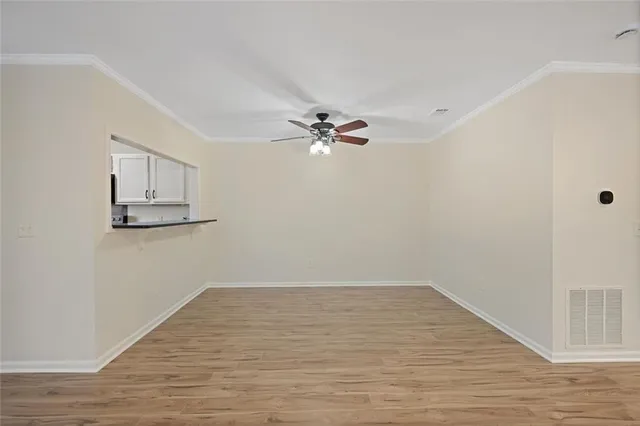 a view of a room with wooden floor and a ceiling fan