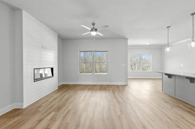 a view of an empty room with a window and wooden floor