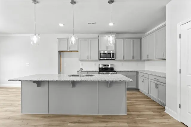 a kitchen with stainless steel appliances granite countertop a sink a stove and cabinets