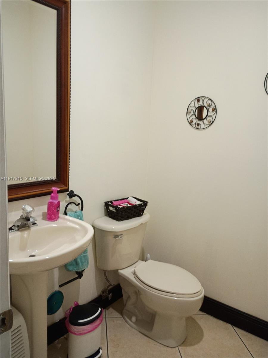13274 Southwest 142nd Terrace, Unit 13274 Miami, FL 33186 - Photo 11 of 32 a white toilet sitting next to a bathroom sink