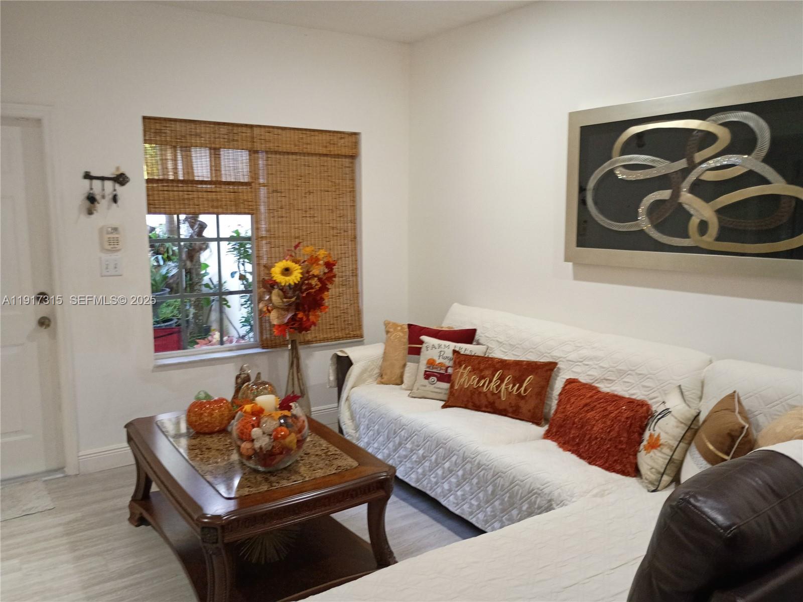 13274 Southwest 142nd Terrace, Unit 13274 Miami, FL 33186 - Photo 12 of 32 a living room with furniture and a potted plant