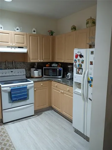 a kitchen with appliances a sink and cabinets